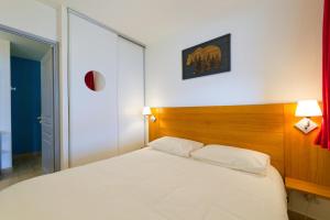 une chambre avec un lit blanc avec une tête de lit en bois dans l'établissement Au bon endroit N3 - Appartement 2 pièces 5/7 personnes - proche pistes - Belle vue montagne, à Orcières