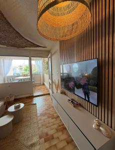 Μια τηλεόραση ή/και κέντρο ψυχαγωγίας στο 4 couchages Vue port avec piscine et parking