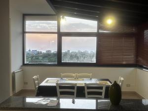 a table and chairs in a room with a large window at Roby's House in Capo dʼOrlando