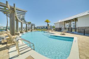 a swimming pool with chairs and a building at Beautiful PCB Getaway Less Than 3 Mi to the Beach! in Panama City Beach