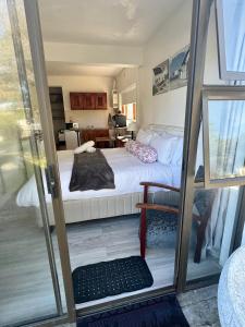 a small bedroom with a bed and a mirror at Joy-South Studio in Agulhas