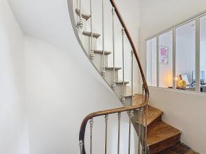 una escalera de caracol en una casa con ventana en La Rose du Roc - Maison 4 niveaux, terrasse vue mer, en Granville