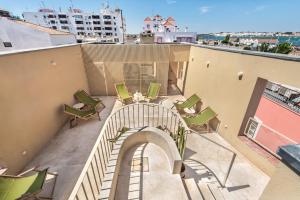 ein Balkon mit einer Treppe und Stühlen auf einem Gebäude in der Unterkunft Palacete do Guadiana by MY CHOICE in Vila Real de Santo António