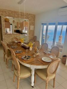 a dining room with a large wooden table with chairs at Villa Naïm Esterel in Saint-Raphaël