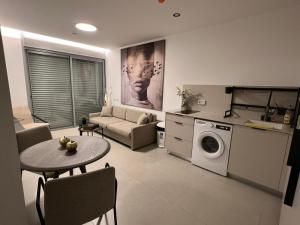 a living room with a table and a washing machine at Emmanuel suits in Eilat
