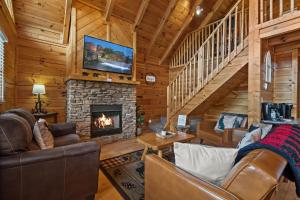 a living room with a fireplace and a tv at Escape to the Smokies- Pool, hot tub, cozy cabin, Pigeon Forge in Pigeon Forge