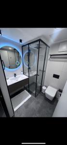 a bathroom with a toilet and a sink and a mirror at Emmanuel suits in Eilat