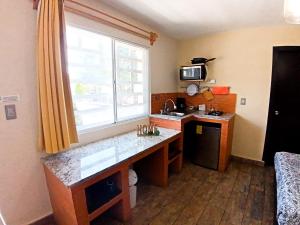 a kitchen with a counter and a sink and a window at Habitación arena, Paseo Durango in Durango