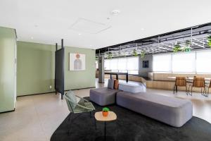 a living room with a couch and a table and chairs at BSR Luxe Studio next to Allianz Park w Rooftop Pool and Pet Friendly in São Paulo