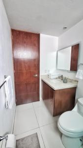 ein Badezimmer mit Toilette und Waschbecken und einer Tür in der Unterkunft Puebla Vista Malinche in Lomas de Angelopolis