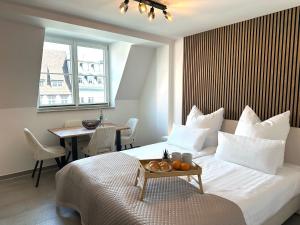 a bedroom with a bed with a table and a dining room at Ferienwohnungen Vito's Apartments Ravensburg in Ravensburg