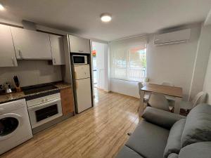 a kitchen and living room with a couch and a table at APCOSTAS Palmavera Playa de la Conxa in Oropesa del Mar