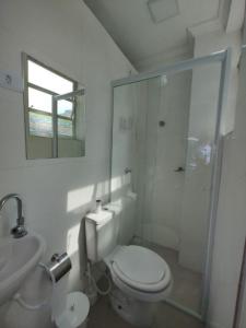 Un baño blanco con inodoro y ducha. en Apê da Pê, en Praia Grande 12 fotos más