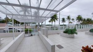 Una vista de un edificio con palmeras y el océano. en Apê da Pê, en Praia Grande