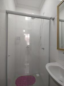 Un baño con ducha con puerta de cristal en Apê da Pê, en Praia Grande