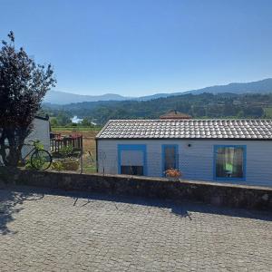 a white building with blue windows on a brick road at Casa Cany in Barreiros +7 photos