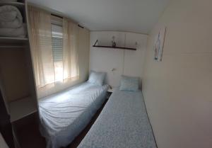 a small bedroom with a bed and a window at Casa Cany in Barreiros