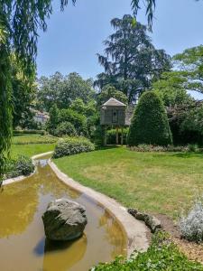 a pond with a rock and a house in the background at Appartement à 2 pas du centre, 2 chambres, parking in Aurillac