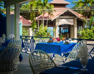 uma mesa com mesas azuis e cadeiras num pátio em Deja Resort All Inclusive em Montego Bay