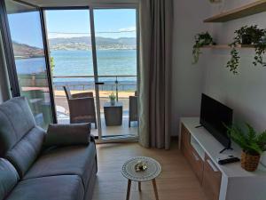 ein Wohnzimmer mit Sofa und Meerblick in der Unterkunft Combarro Mar in Combarro