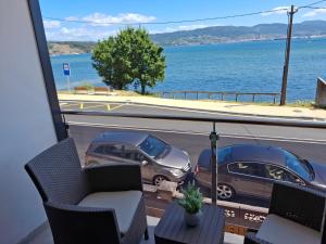 ein Balkon mit zwei Stühlen und Blick aufs Wasser in der Unterkunft Combarro Mar in Combarro