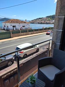 ein Balkon mit einem auf der Straße geparkten Auto in der Unterkunft Combarro Mar in Combarro