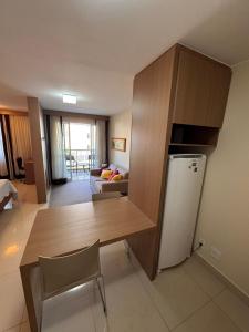 a kitchen and living room with a table and a refrigerator at The Sun - Flat in Brasilia