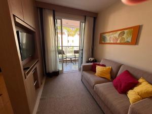 a living room with a couch and a television at The Sun - Flat in Brasilia