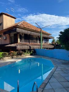 a swimming pool in front of a house at Pousada La Floratta in Paulista