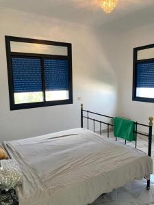 アル・ホセイマにあるDream rentals - greenのベッドと2つの窓がある寝室