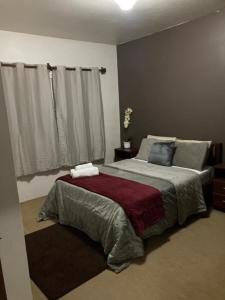 Un dormitorio con una cama grande y una ventana en Casa Planalto Gramado, en Gramado