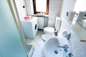 a white bathroom with a toilet and a sink at Terrazza di Alfieri - Alloggio con terrazza privata nel centro di Asti in Asti +16 photos