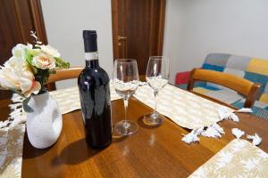 a bottle of wine and two wine glasses on a table at Terrazza di Alfieri - Alloggio con terrazza privata nel centro di Asti in Asti