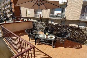 a table and chairs with an umbrella on a balcony at Terrazza di Alfieri - Alloggio con terrazza privata nel centro di Asti in Asti