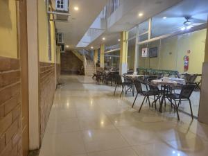 a dining area with tables and chairs in a building at Pousada Casa Verde in Aparecida