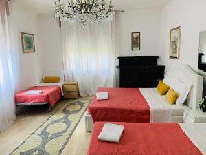 Un dormitorio con dos camas y una lámpara de araña. en Venice Popular Stay, en Mestre