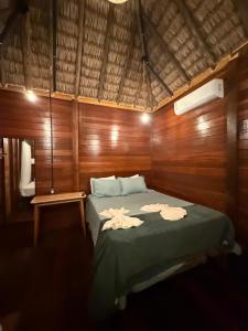 a bedroom with a bed with two towels on it at AREIA BRANCA Chalés in Santo Amaro