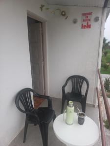 two black chairs and a table with a bottle on it at Confort Alojamiento in Formosa