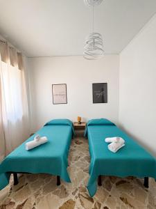 パレルモにあるCasa Nonna Pinaの青いクッション付きの部屋のベッド2台