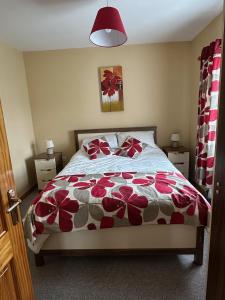 a bedroom with a bed with red flowers on it at A home in Bundoran in Bundoran