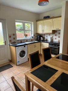a kitchen with a washing machine and a table with chairs at A home in Bundoran in Bundoran