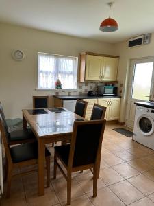 a kitchen with a dining room table and chairs at A home in Bundoran in Bundoran +2 photos