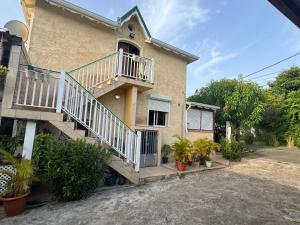 a house with stairs and plants in front of it at Colibri studio in Les Abymes