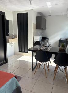 a kitchen with a table and chairs in a room at Loft casal - Centro de Bombinhas in Bombinhas