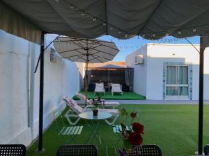 a patio with a table and chairs and an umbrella at Anchor House in Albufeira