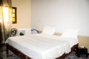 a bedroom with a large bed with white sheets at Havre de paix in Saint-Louis