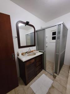 Un baño con lavabo y ducha con espejo. en Casa Planalto Gramado, en Gramado 28 fotos más