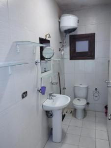 a white bathroom with a sink and a toilet at 80-1 CRISS RESORT-CITY CENTER-NAAMA BAy in Sharm El Sheikh