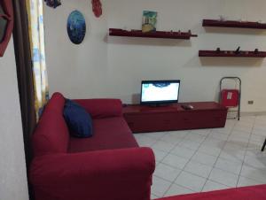 a living room with a red couch and a tv at 80-1 CRISS RESORT-CITY CENTER-NAAMA BAy in Sharm El Sheikh +7 photos