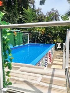 a swimming pool in a yard next to a porch at Cabinas Ole Caribe in Puerto Viejo
